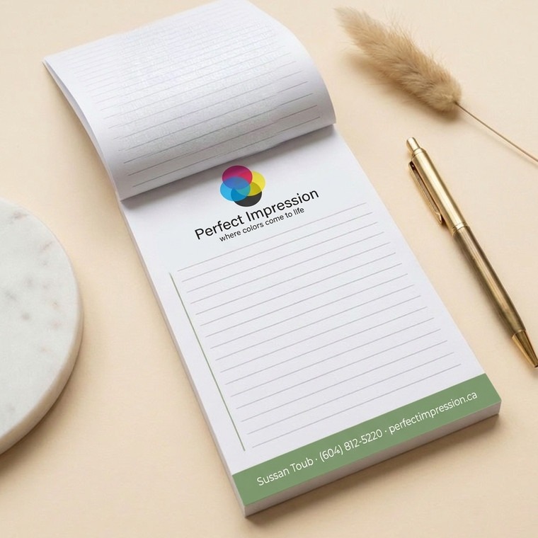Notepad flipped open beside a gold pen